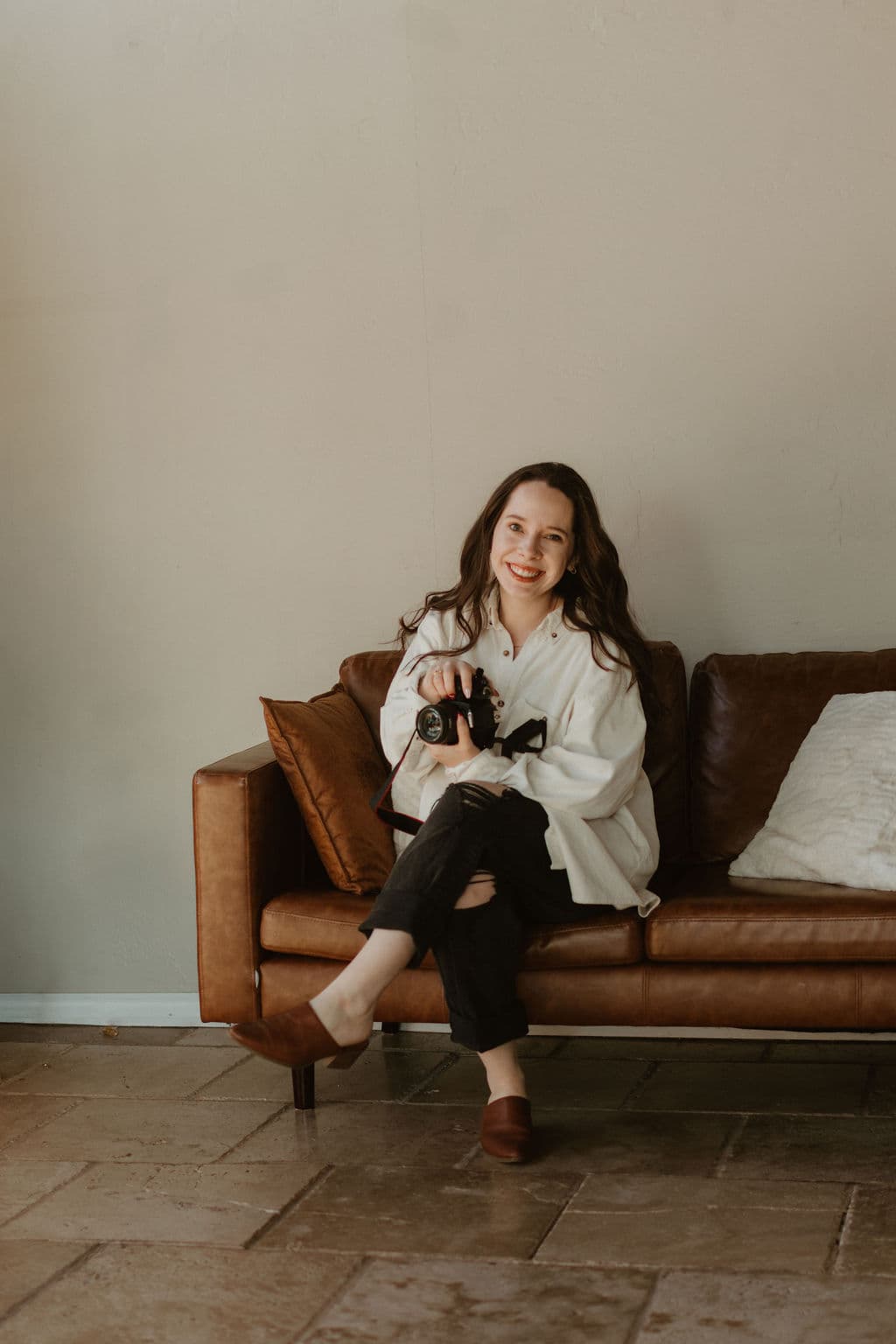 Lauren sitting on couch with camera