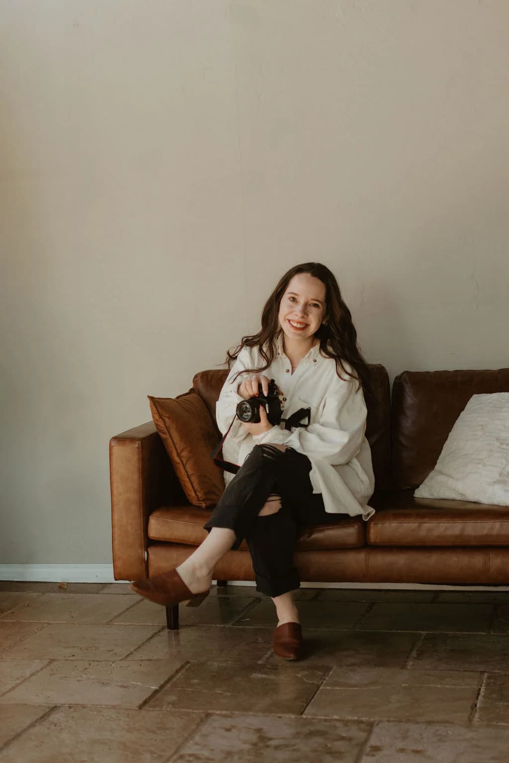 Lauren sitting on couch with camera